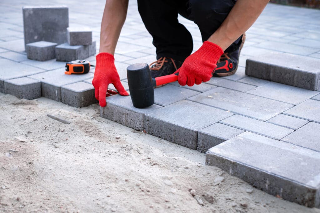 A man laying down block paving concrete