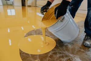 A Construction Worker Apply Epoxy Resin In An Industrial Hall