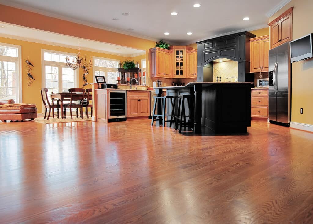 A large expanse of wood flooring in a kitchen and dining room