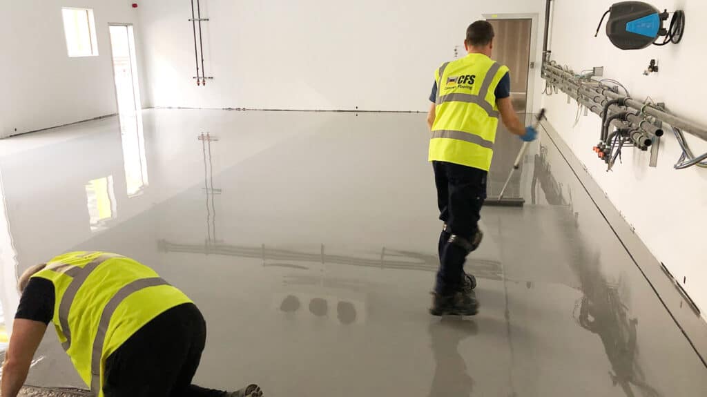 poured resin flooring with two contractors working