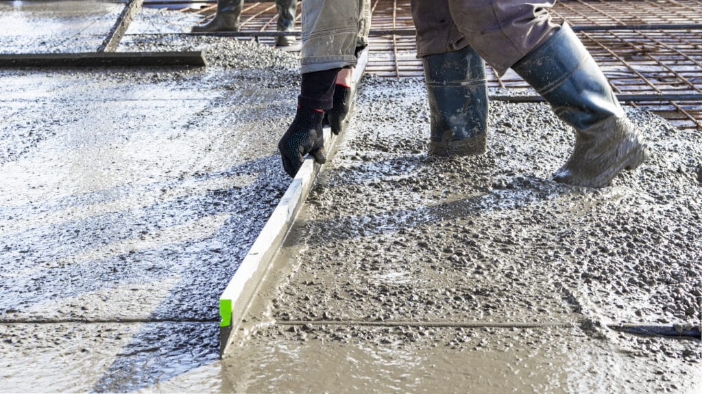 Construction worker levelling a reinforced concrete floor